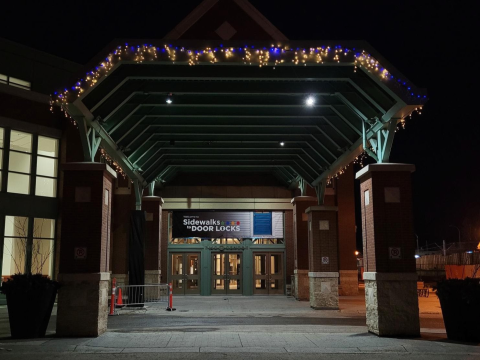 At night: entranceway to the Calgary BMO Centre, decorated with lights and a Sidewalks to Door Locks