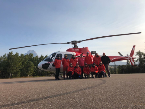 Southwest Alberta Regional Search and Rescue volunteers posing in front of a helicopter 